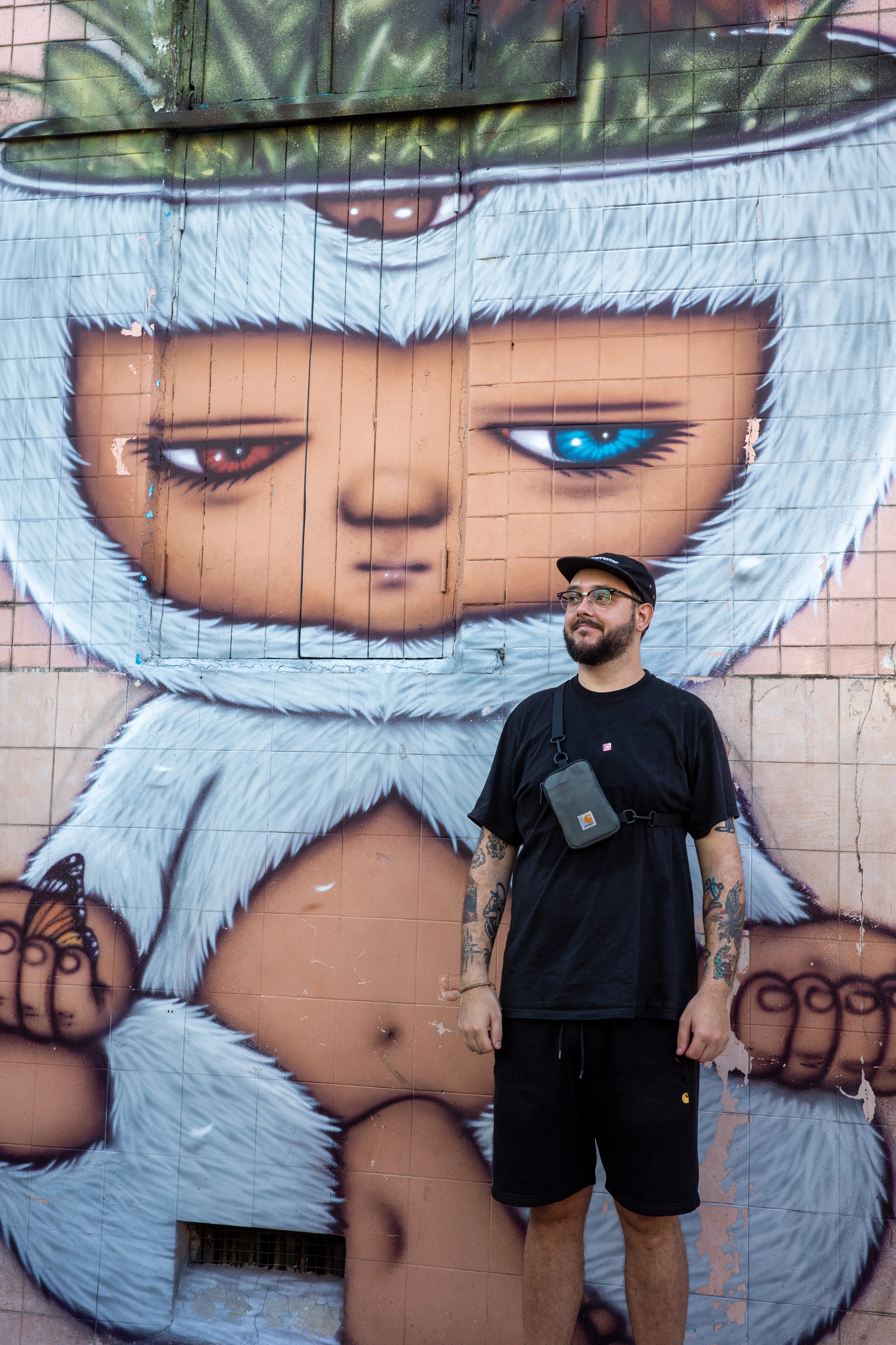 Callum Bonnyman standing in front of a painted mural